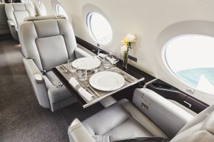 Luxury private jet interior with tray table and champagne — RYL Jets charter experience