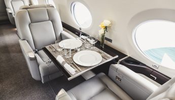 Luxury private jet interior with tray table and champagne — RYL Jets charter experience